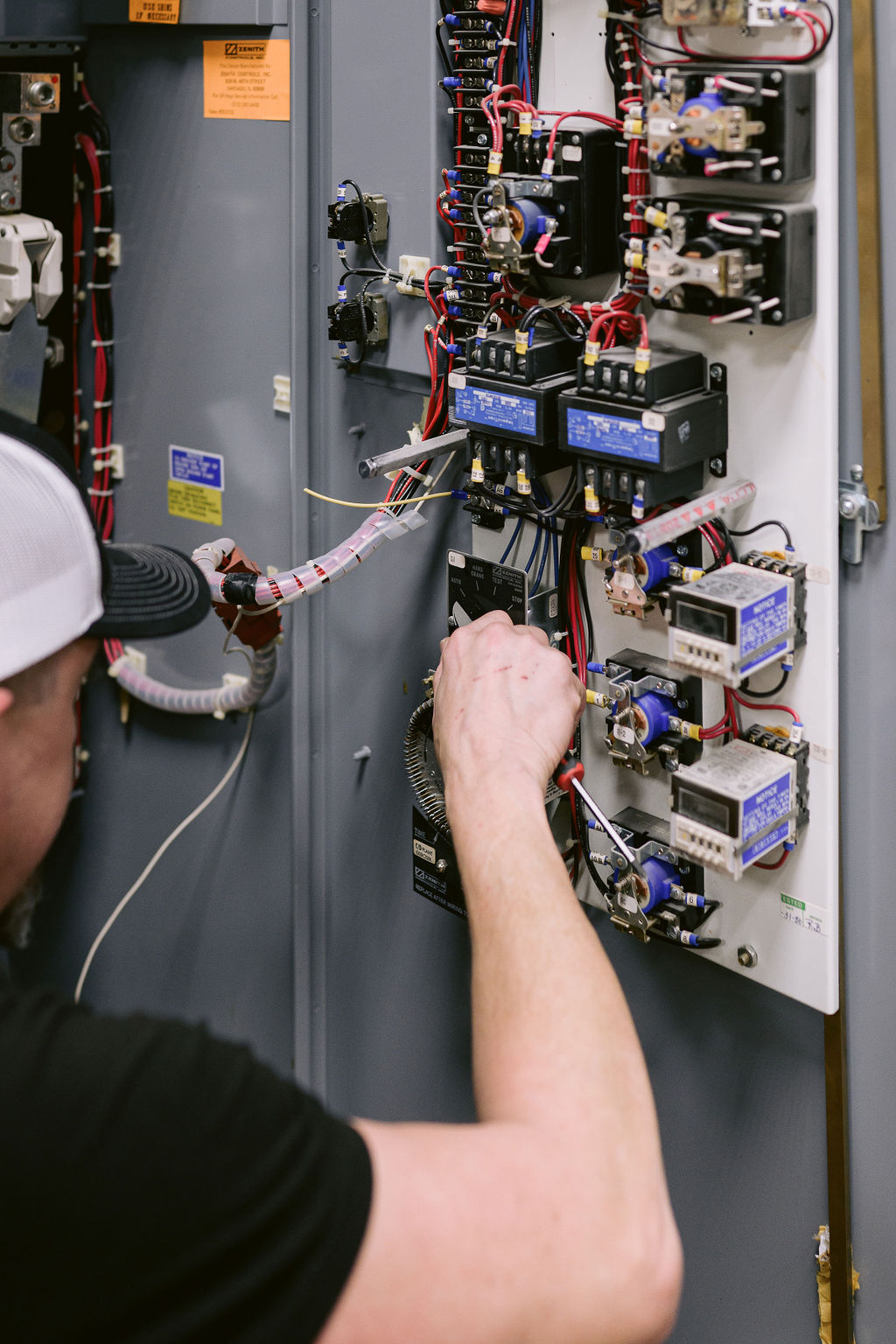 Electrician working on electrical breaker panel